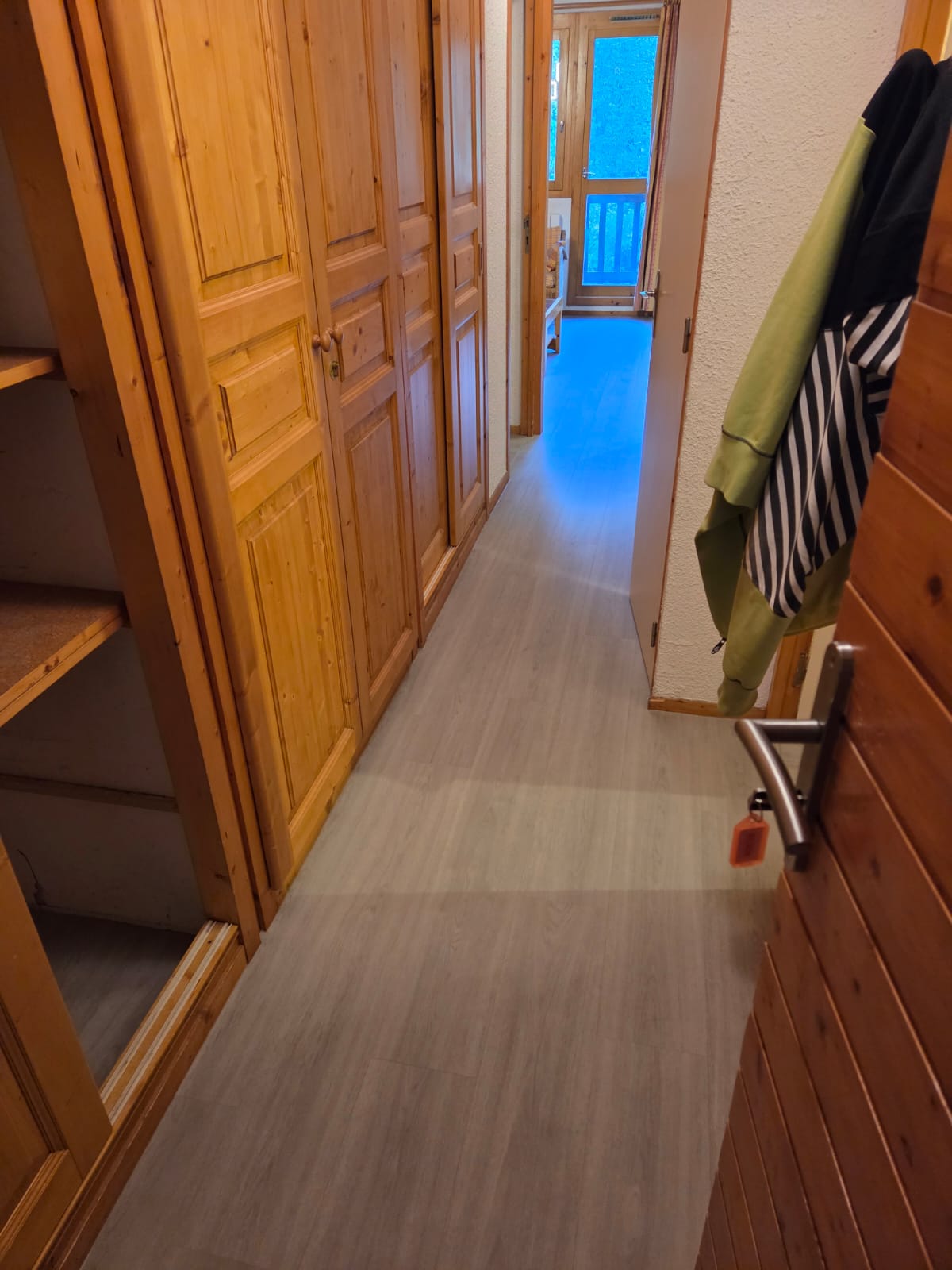 Couloir avec sol en PVC imitation bois et murs blancs