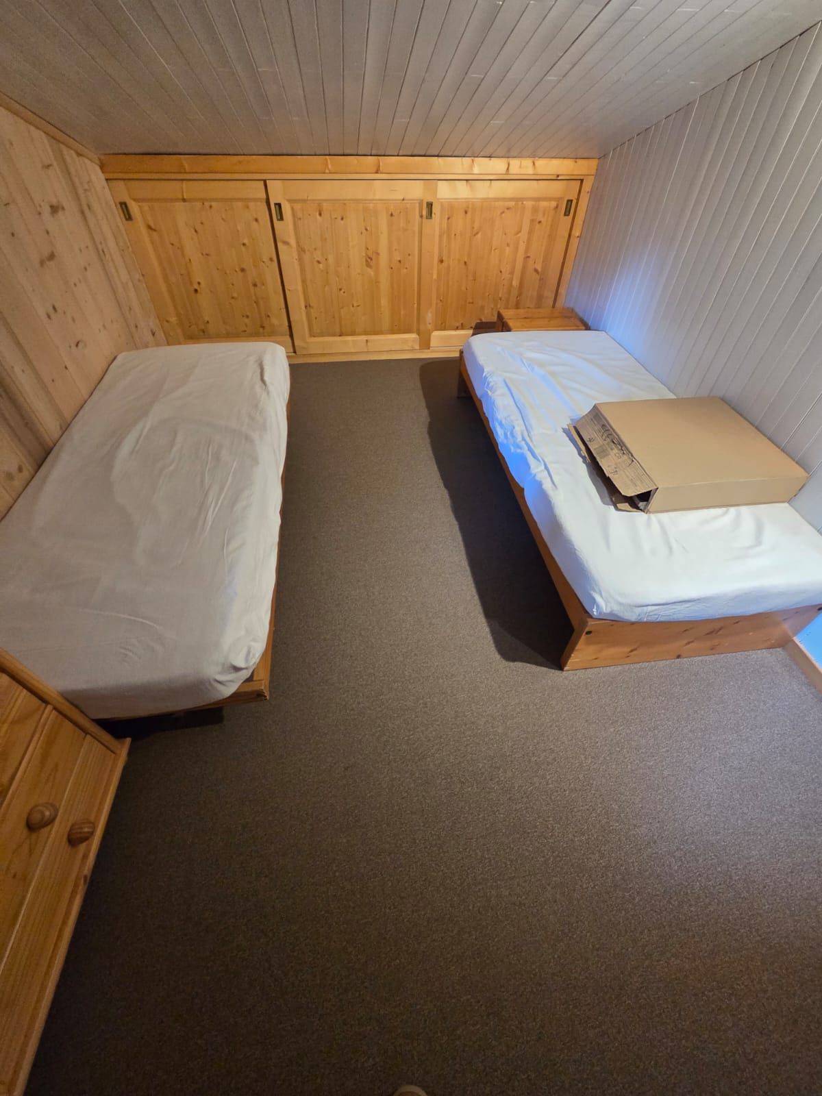 Chambre en cours de finition avec sol souple PVC et lits en bois