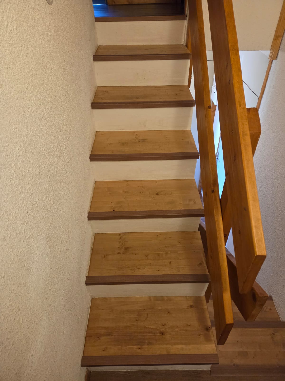Escalier avec marches en PVC souple et contremarches en bois clair, finition mat.