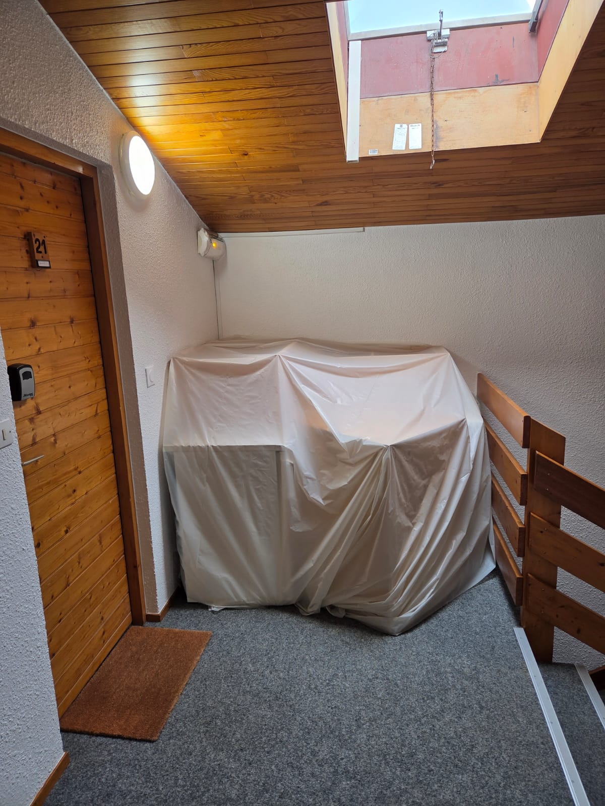 Couloir en cours de peinture avec mur blanc et plafond en bois clair